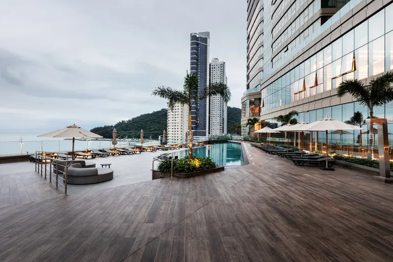 Deck da piscina jovem, com vista para o mar e as torres